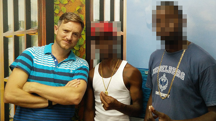 The author poses with two former gang members in Belize 
