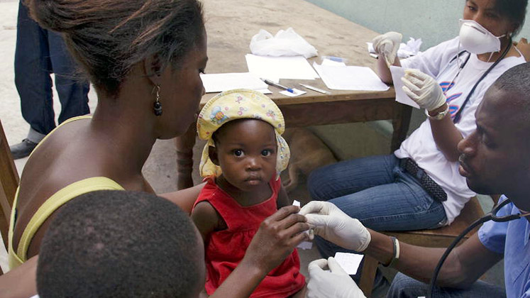 A member of a Cuban-Haitian medical brigade treating a baby girl in Port-au-Prince