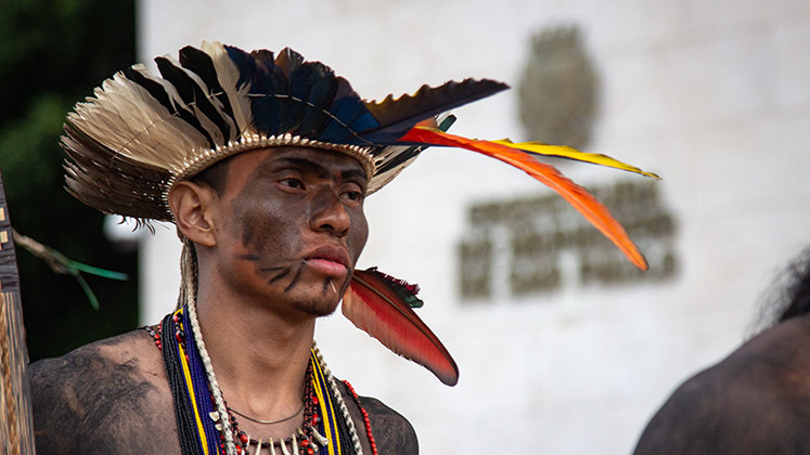 A Guarani man in a headdress stands outside the Sao Paulo Municipal Prefecture in Brazil