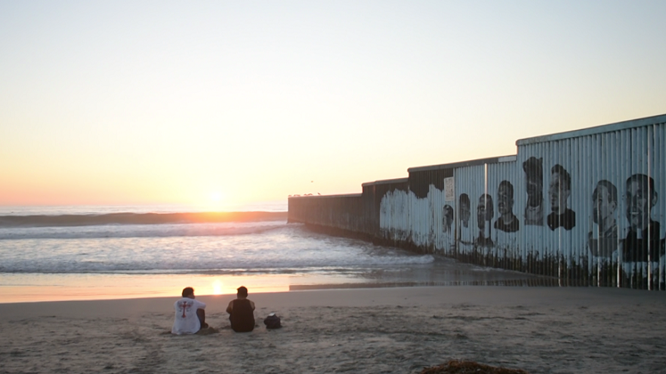 Two men watch the sunset in Tijuana