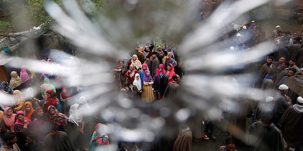 Photo of veiled women through a bullet hole in a window