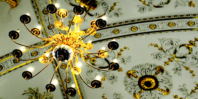 Candelabra hanging from ornate ceiling