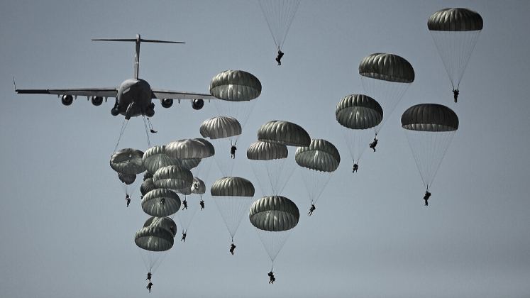 Parachutes dropping from military plane