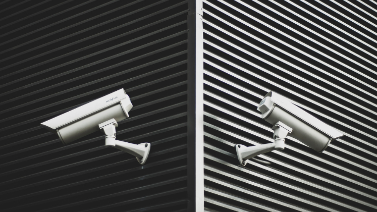 Two surveillance cameras on a wall