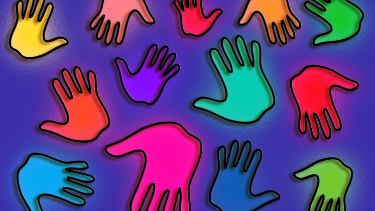Multicoloured hand prints on a purple background