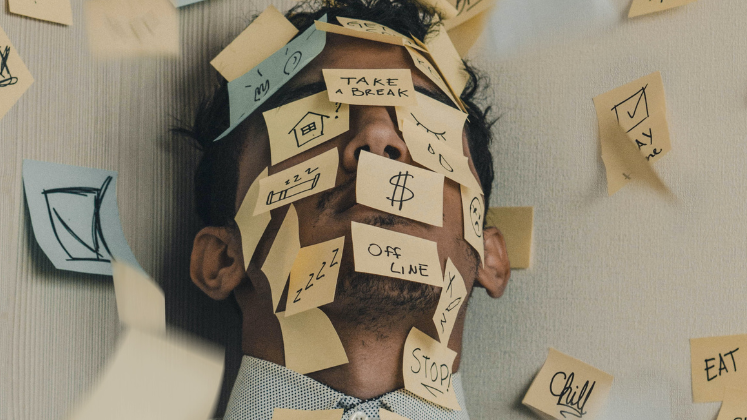 Person covered with post-it notes reading 'off-line', 'zzzz', 'take a break' 