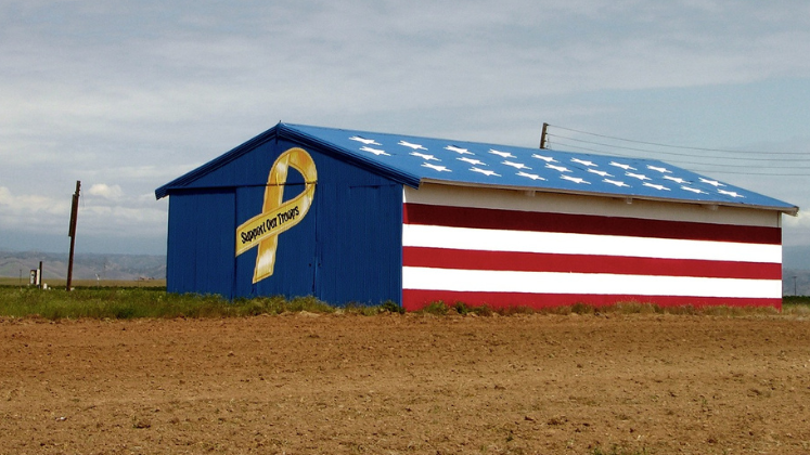 Barn building with American flag and yellow 'Support the Troops' ribbon