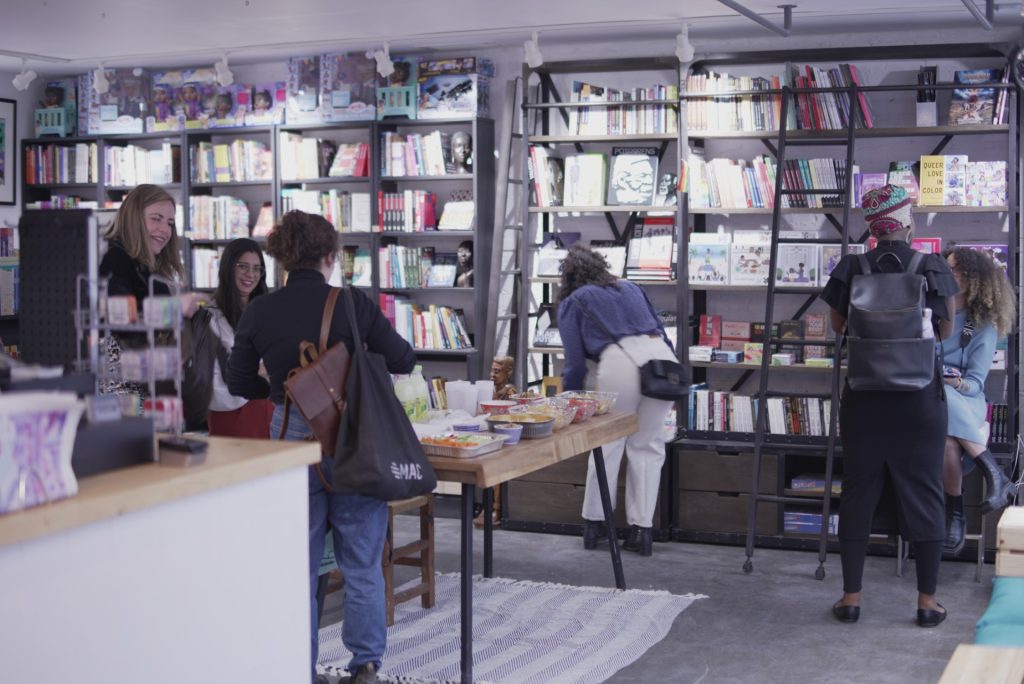 Photo of the interior of Racines bookshop in Montreal showing women shopping for books
