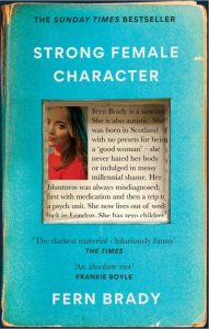 Book cover of Strong Female Character by Fern Brady showing a photograph of a blonde woman (the author) in a red top and a short biography of her life against a blue background.