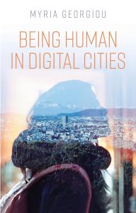 Book cover of Being Human in Digital Cities by Myria Georgiou showing a woman's silhouette against a city in the background.