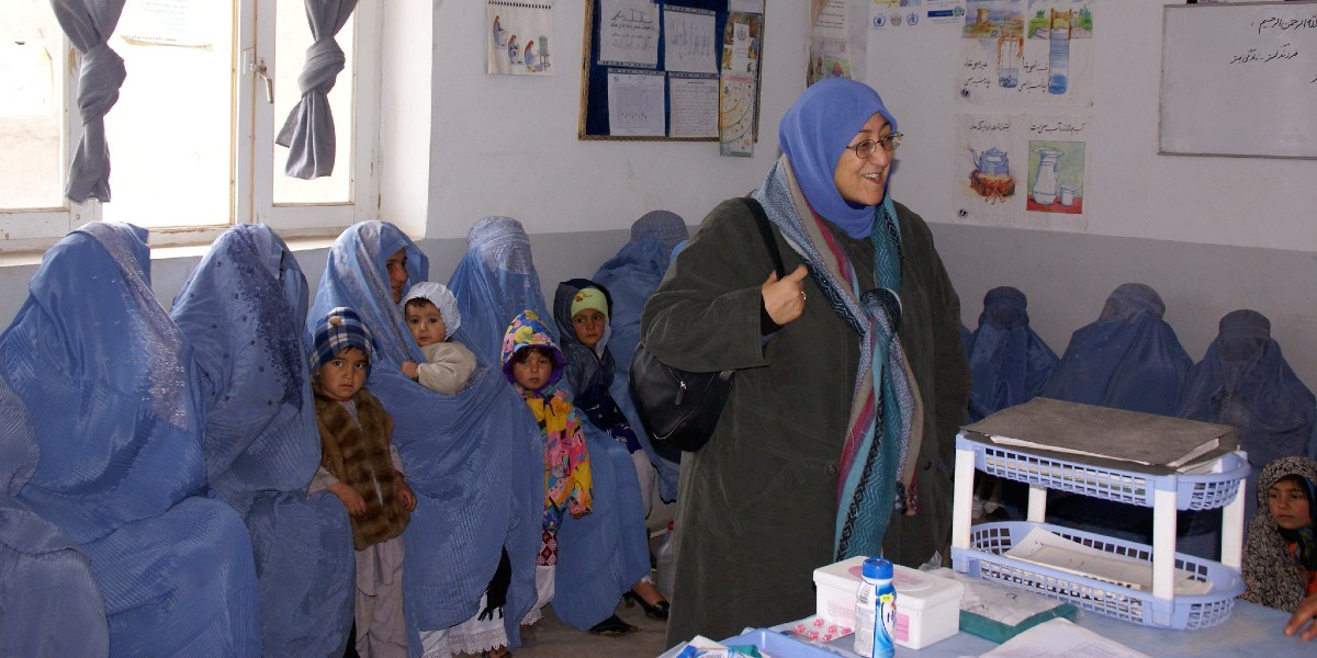 Women in Afghanistan wearing burkhas with small children
