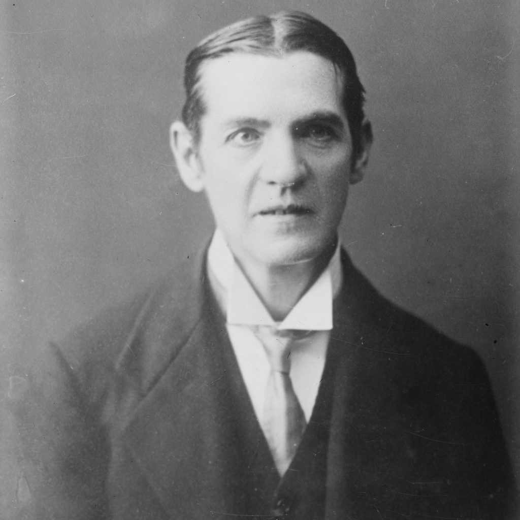 A portrait photo of Thomas Baty wearing a shirt and tie.