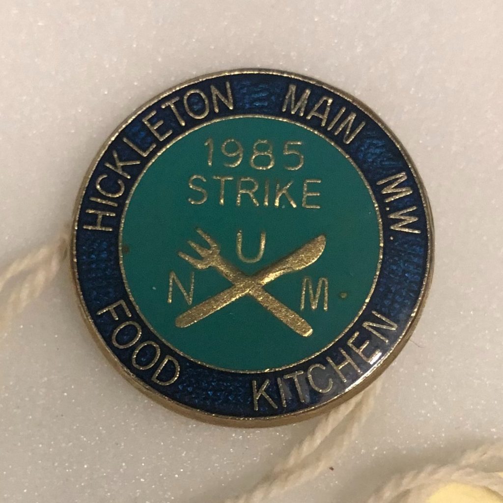 A pin badge with "1985 Strike" written on it and a knife and fork. Around the edges is written "Hickleton Main M.W. Food Kitchen".