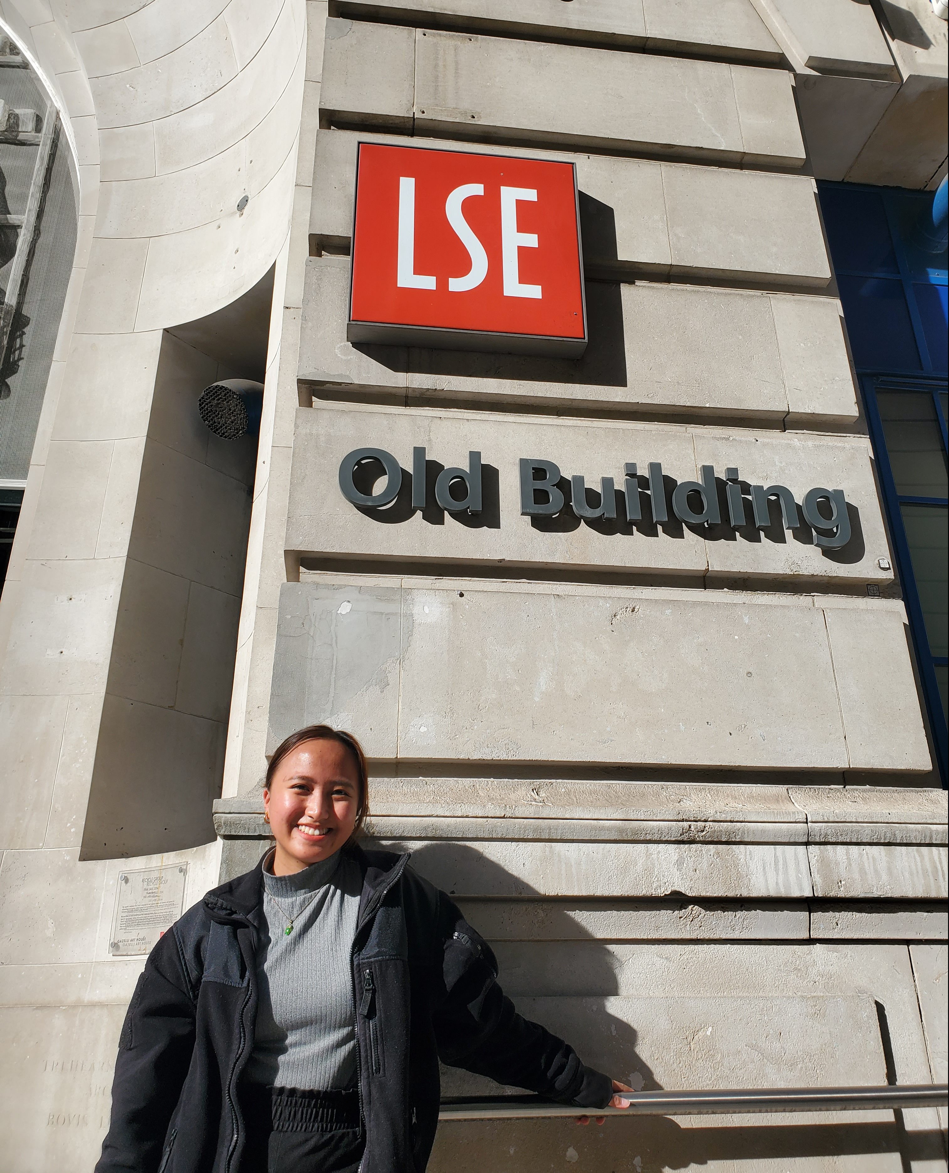 LSE graduate student on campus standing outside the Old Building