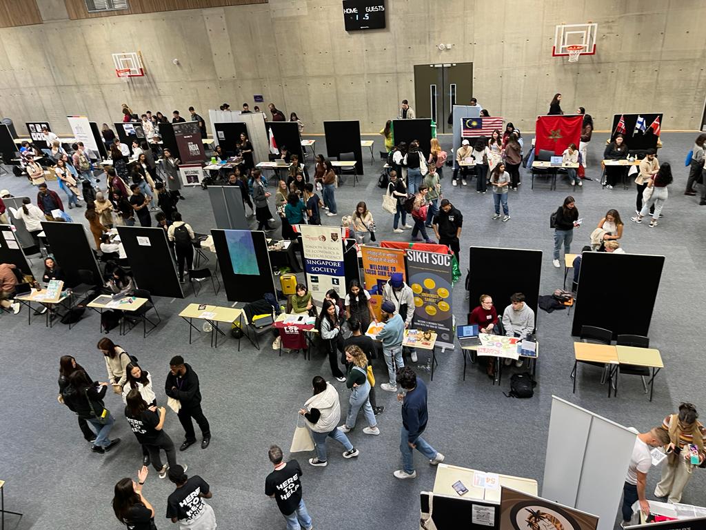 Freshers fair stands with students browsing from September 2022 located in the Marshall building sports hall